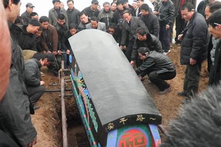 梦见一个熟人死了我把她装在把装在棺材里从我家送回他家是什么意思呀...